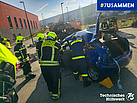 Gruppe von THW und Feuerwehr üben mit Geräten an PKW